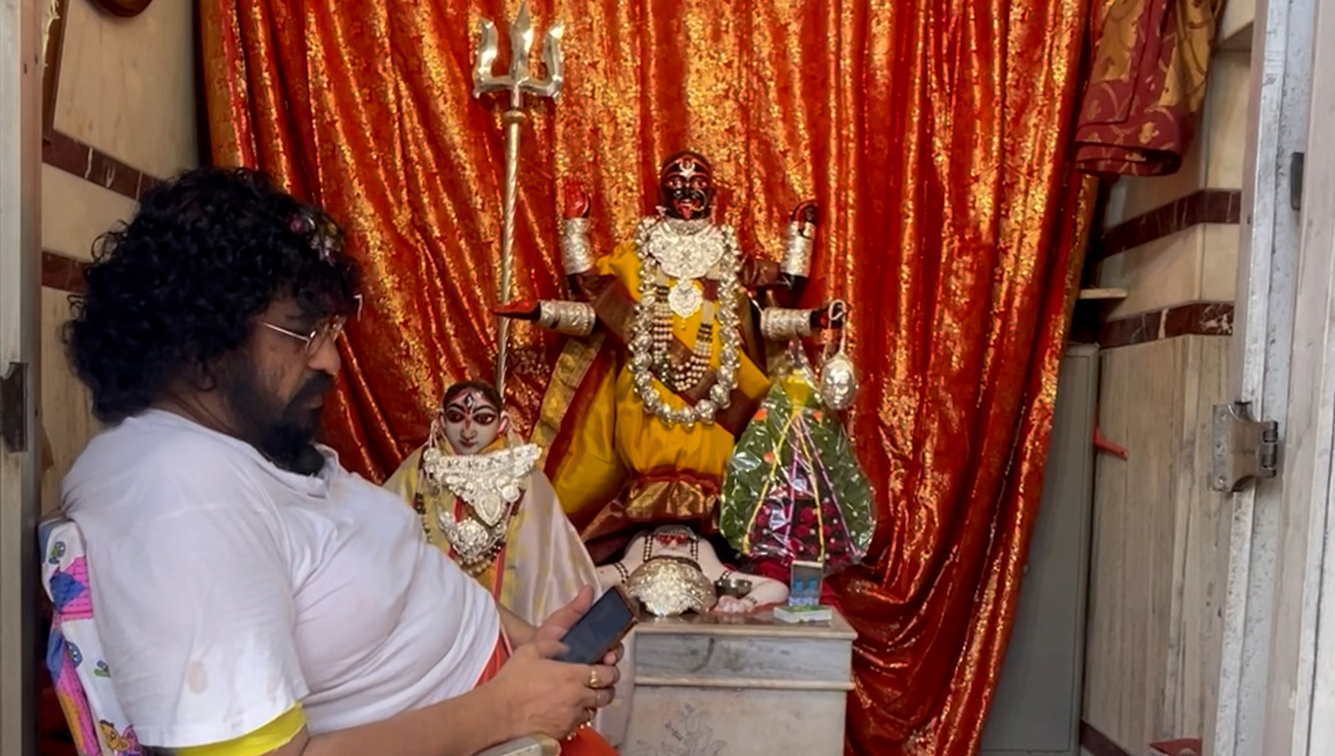 priest sitting beside kaali temple